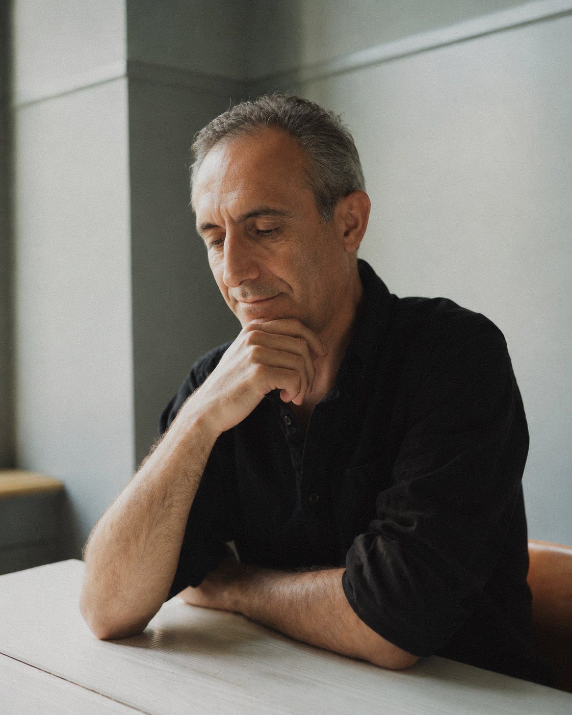 Armen Daneghyan in thought at a table